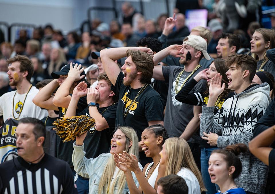 Members of The Herd cheer at a basketball game