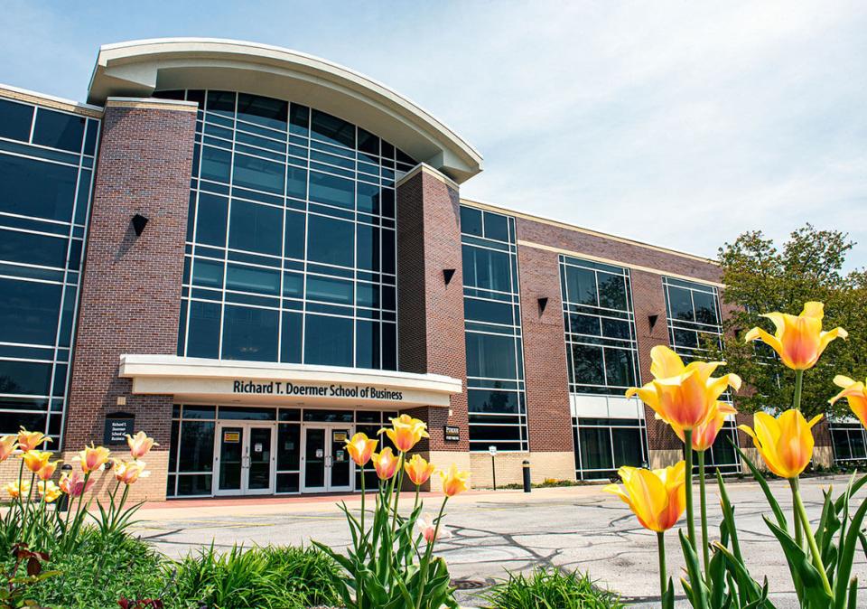 Exterior of the Doermer School of Business Building with flowers in the foreground.