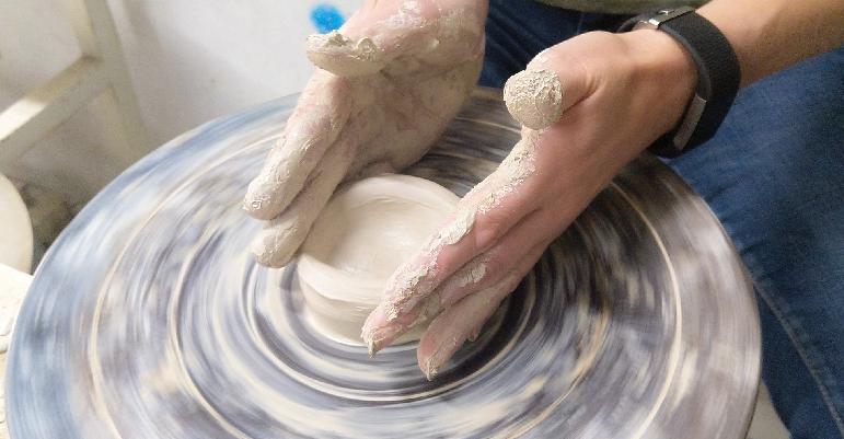 someone throwing pottery on a ceramic wheel