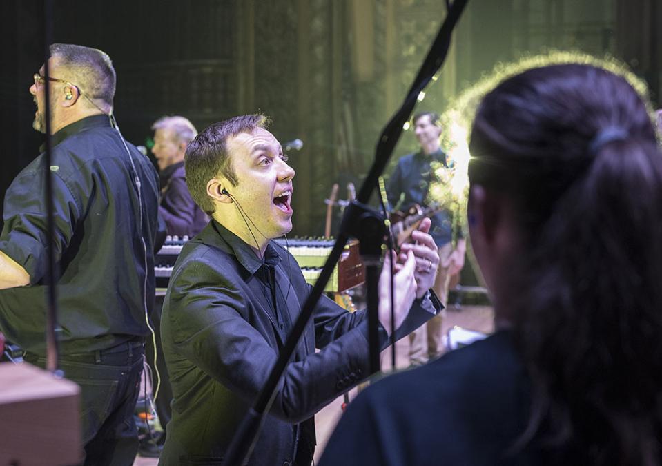 William Sauerland leads the choir at a Pink Droyd concert in the Embassy Theatre.