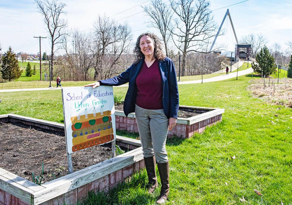 Julie Smith is standing next to a garden bed