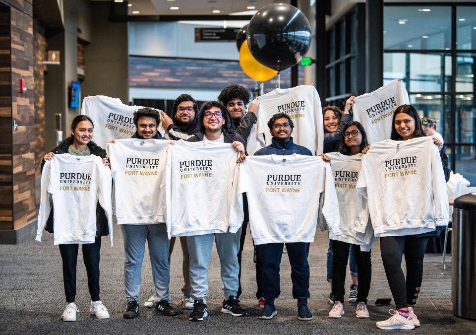 Students hold up PFW sweatshirts.