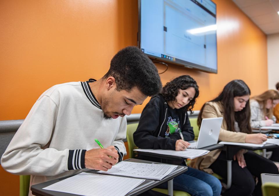 Students writing and working on assignments in class.