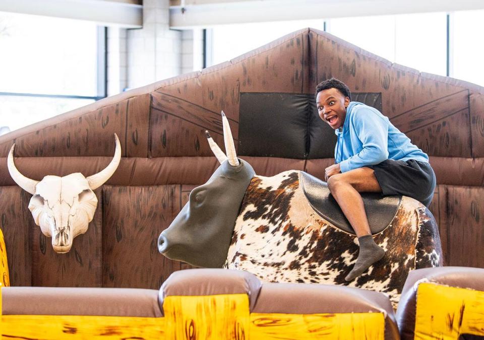 A student is riding a mechanical rodeo bull