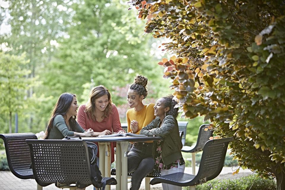 student sitting around an outside table