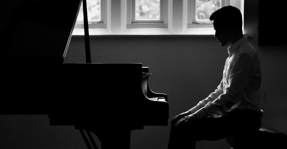 man sitting at piano