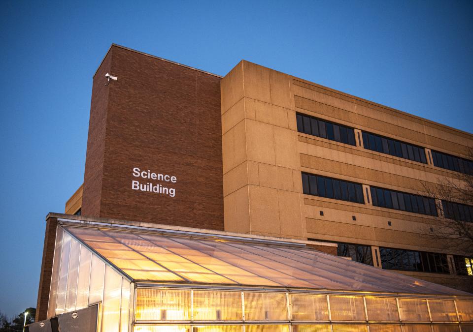 Science building at dusk with the greenhouse in the forefront.