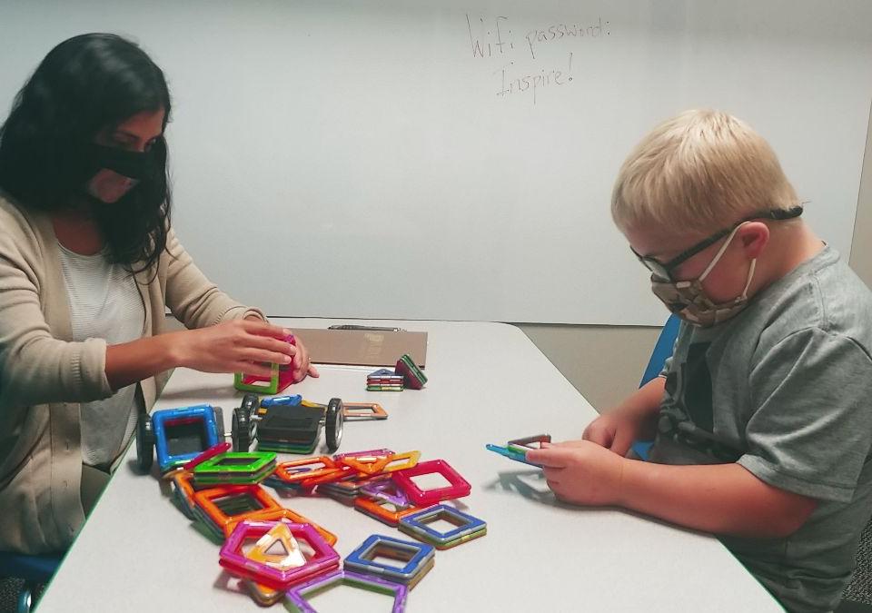 Speech-language pathology graduate student Angela Roberts works with Jackson at GiGi's Playhouse.