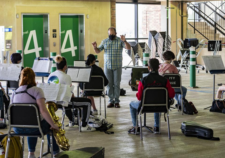 Daniel Tembras conducts a band rehearsal in parking garage 3