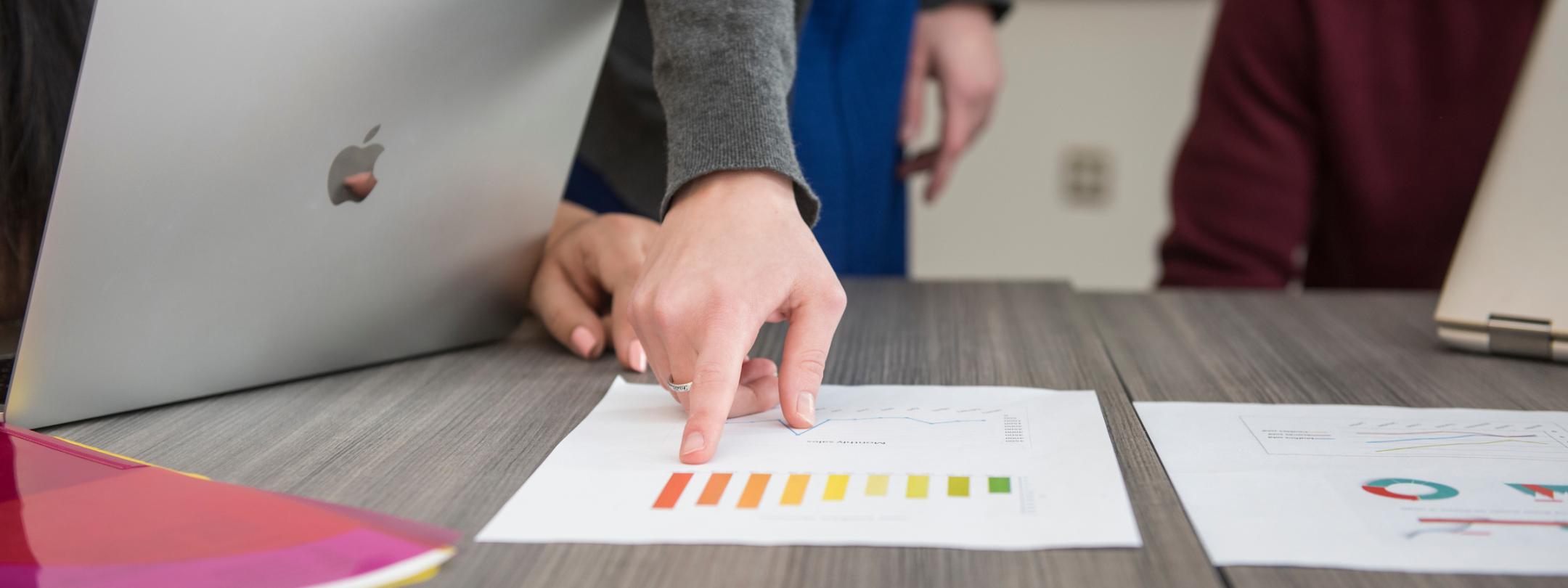 Business students pointing at a graph.