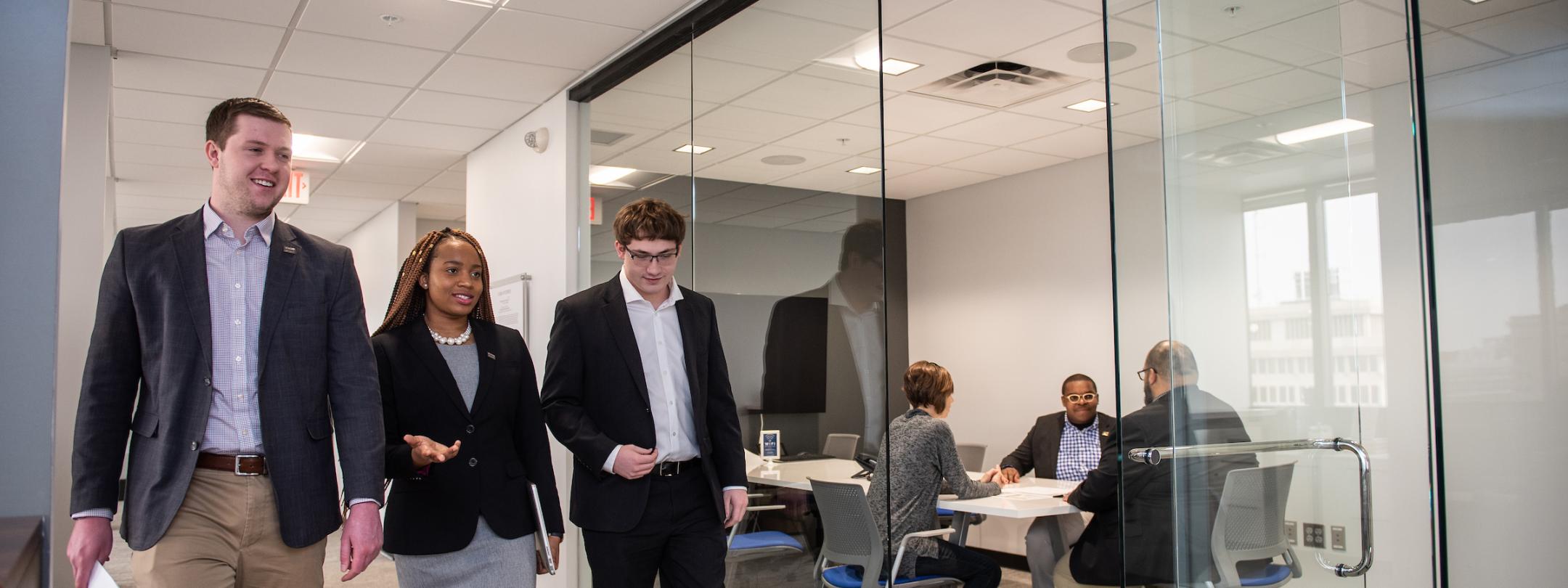 Business students walk down a hallway.