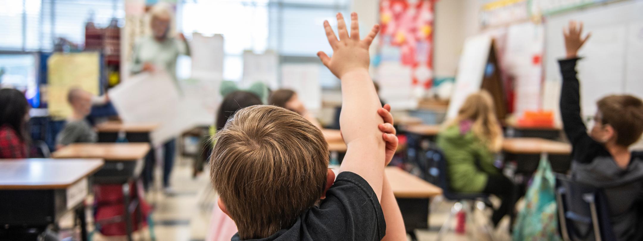 Student raises hand in a student teaching classroom.