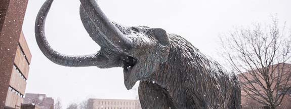 Bronze mastodon statue in the snowy Alumni Plaza