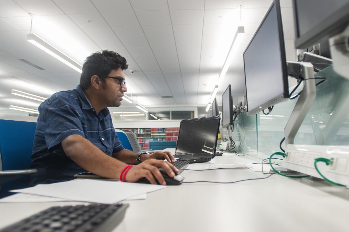 A student works on a computer in the library.