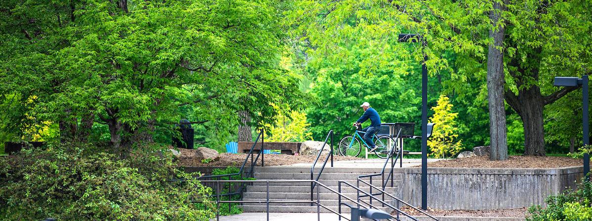 A student riding bike on campus