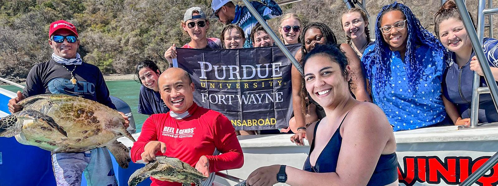 PFW marine biology students and faculty display turtles on a boat