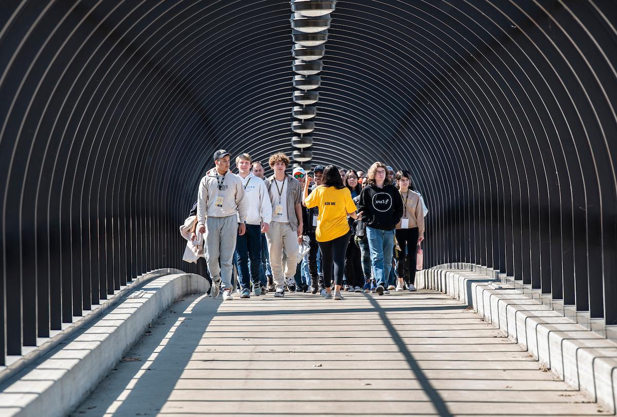 A student worker gives a tour to a large group during a campus visit day.