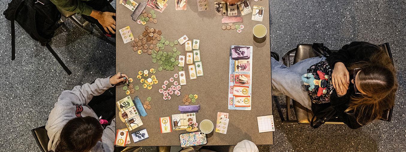 Four people are playing a board game