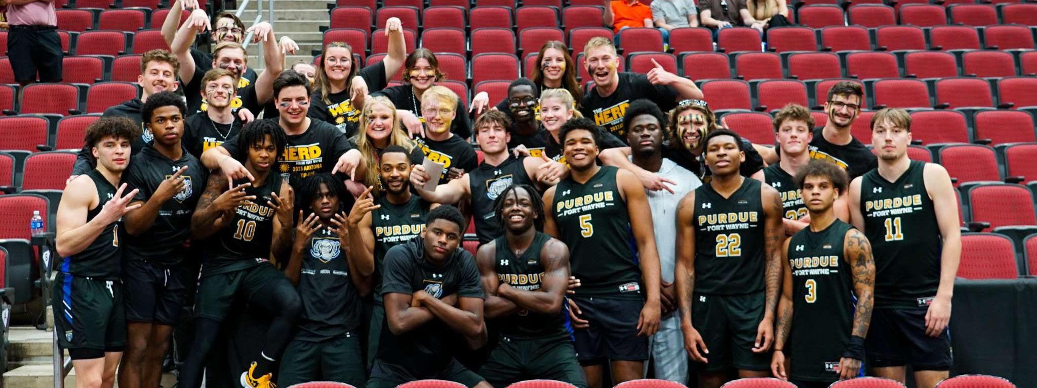 Group photo of The Herd with members of the PFW men's basketball team.