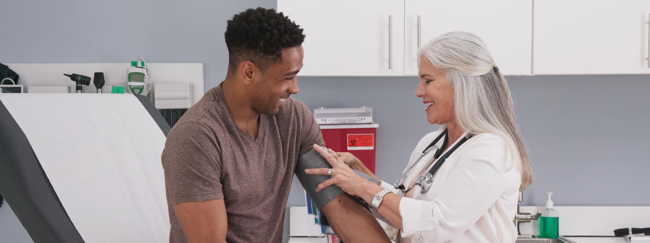 Woman taking blood pressure of patient