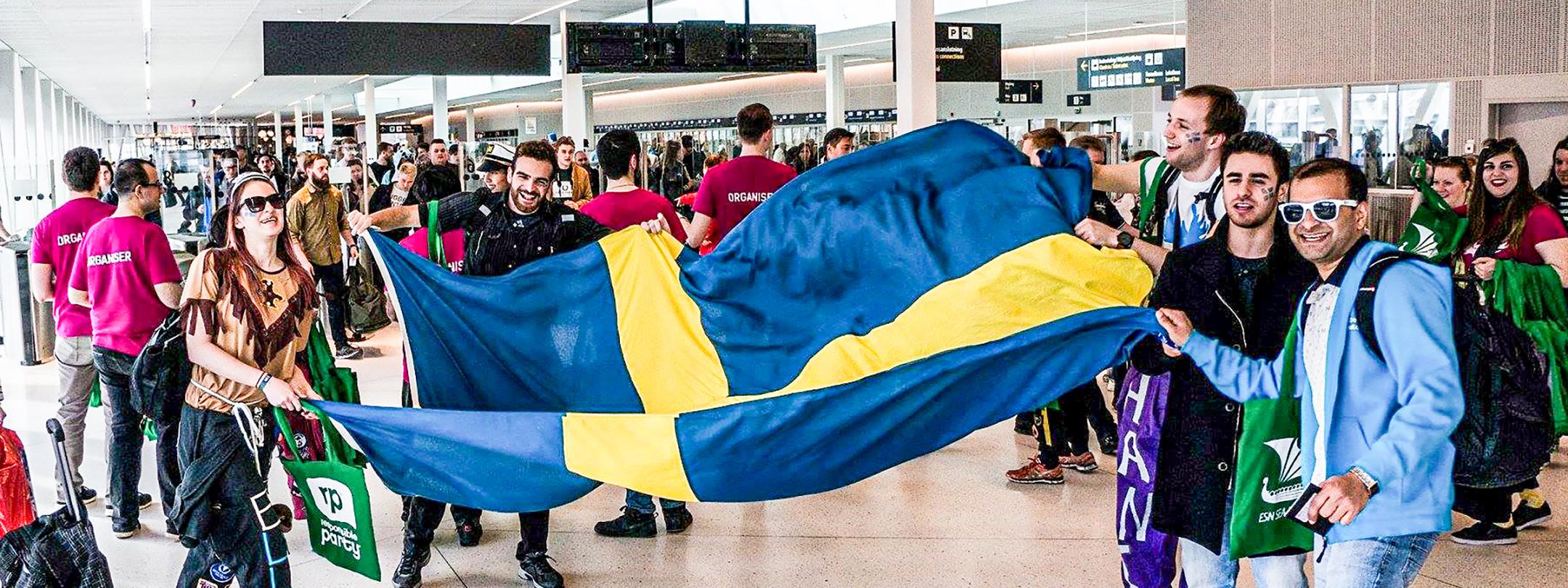 Students holding a flag for the study abroad program.