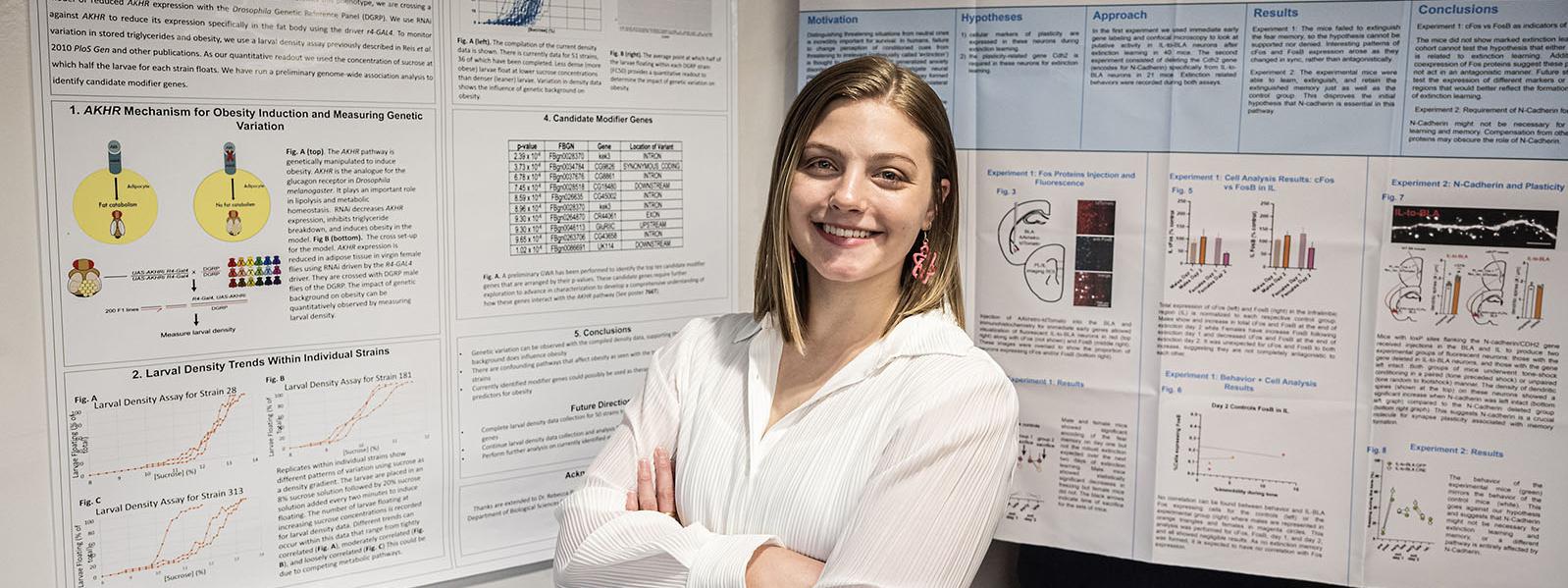 Allison Velie is standing in front of posters