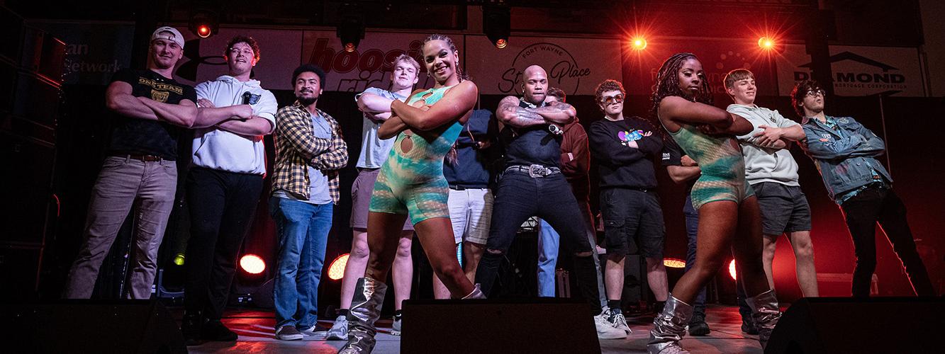 Flo Rida and dancers pose on stage with a group of Purdue University Fort Wayne students