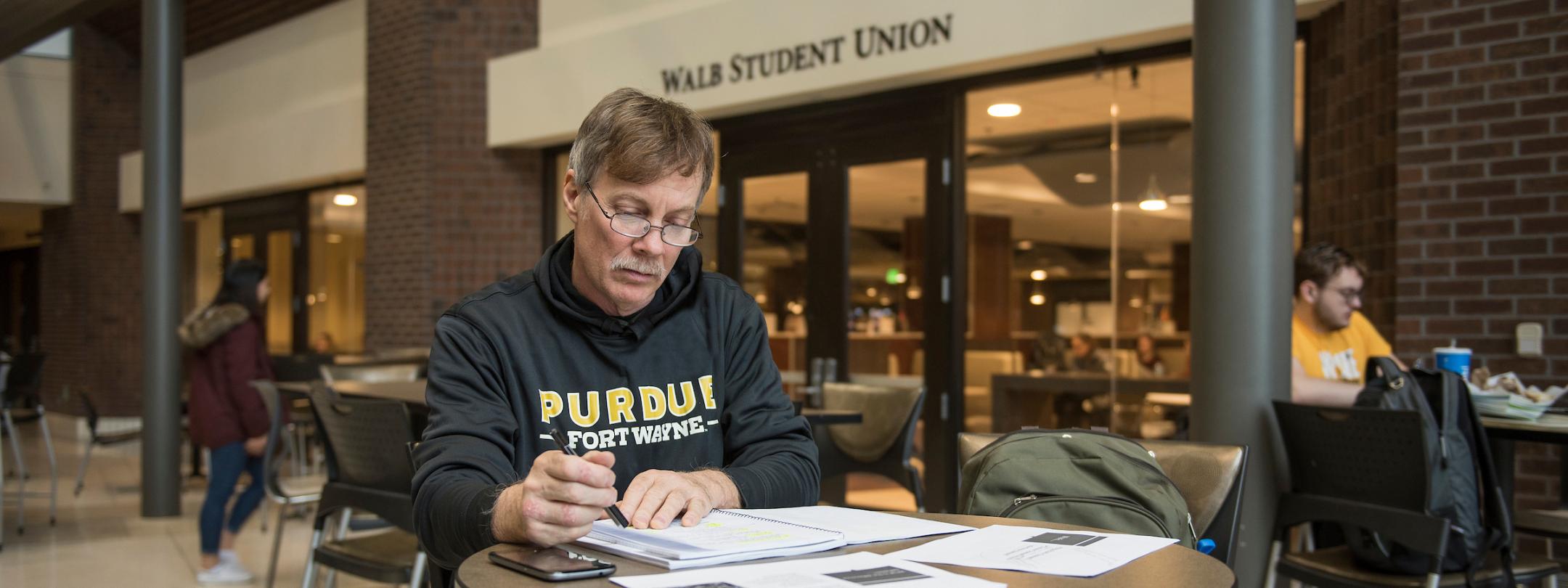 Adult student studying at a table in Wall.