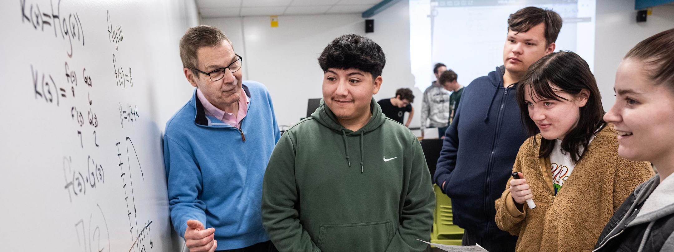 Students and a professor solving a math problem