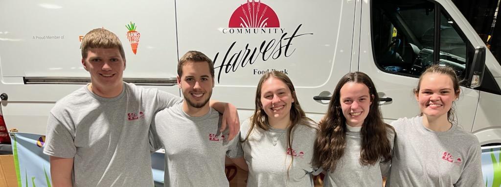 Third year chapman scholars posing in front of a Community Harvest van after volunteering.