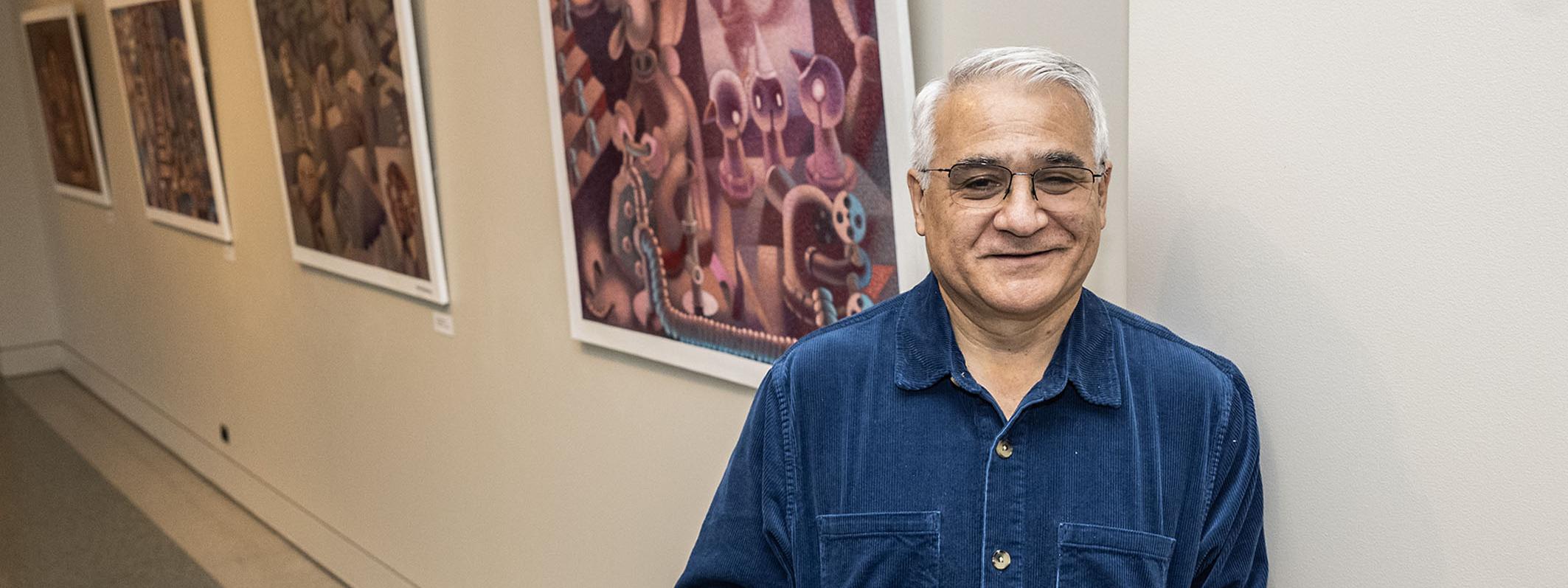 Andres Montenegro standing next to an art exhibit