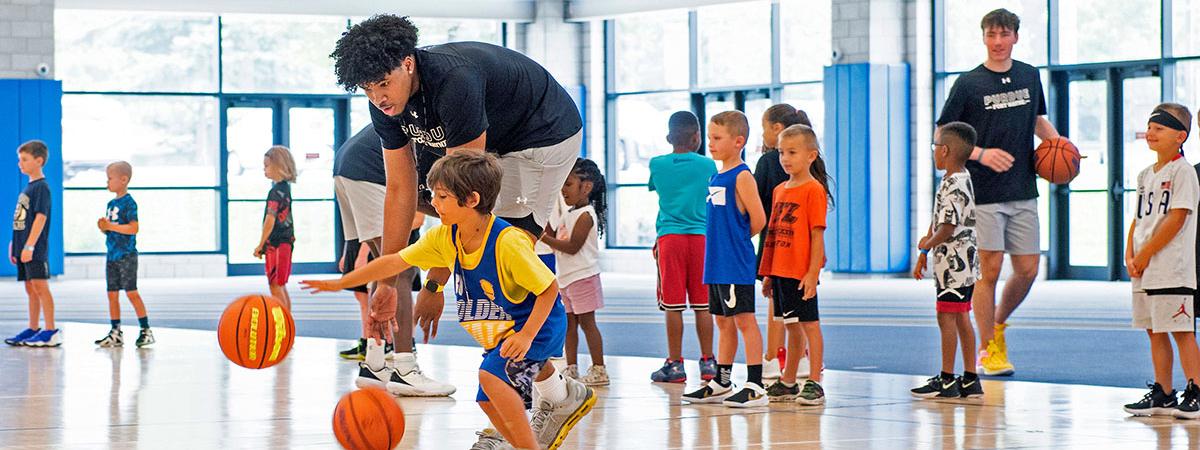 A PFW athlete is teaching at a children's basketball camp