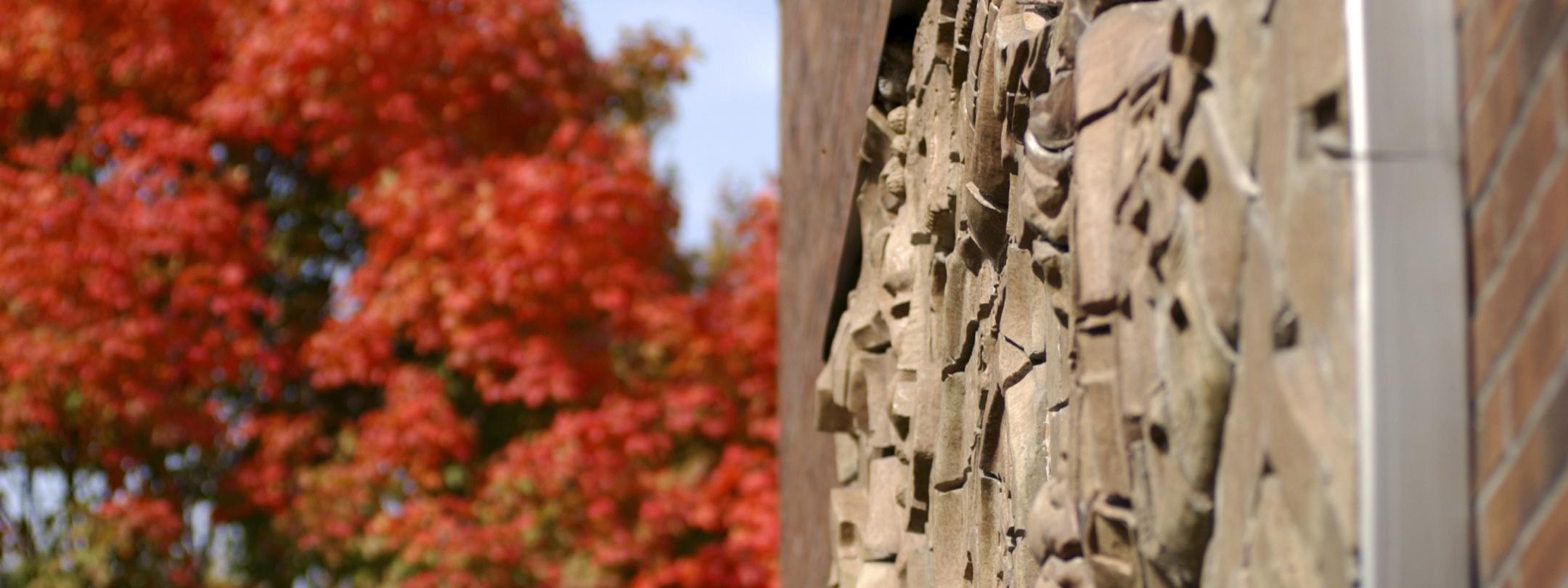 The sculpture named Indiana Landscape is displayed on the building's outside wall of Neff Hall.