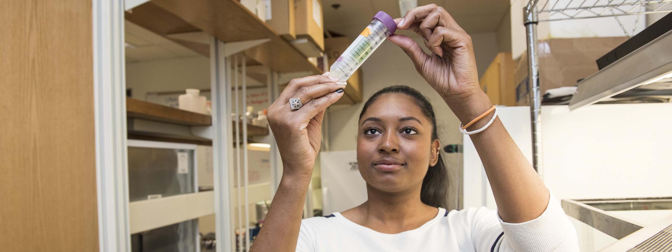 Student examining a sample in a biology lab.