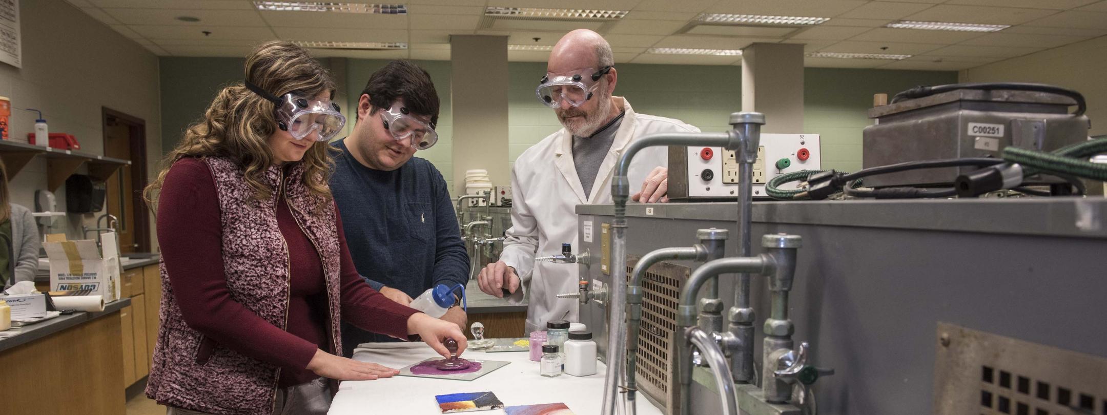 Chemistry lab where professor is discussing the experiment with two students.