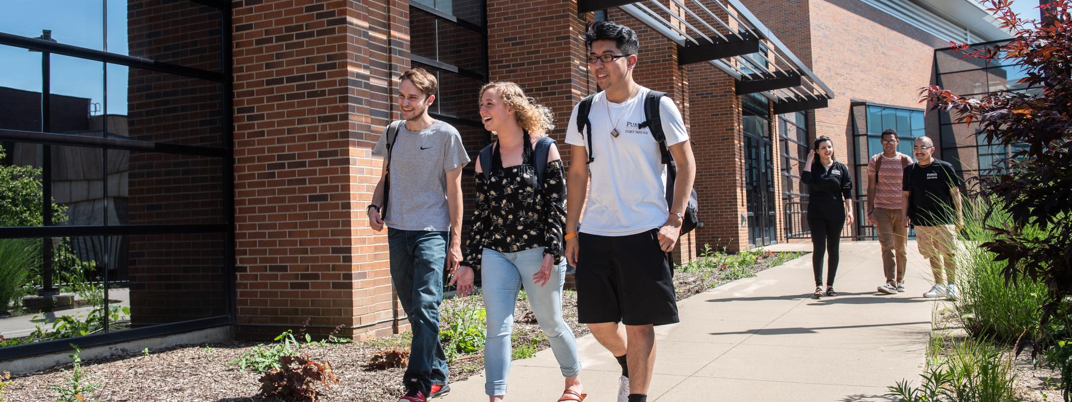 Students walking and discussing their class notes.