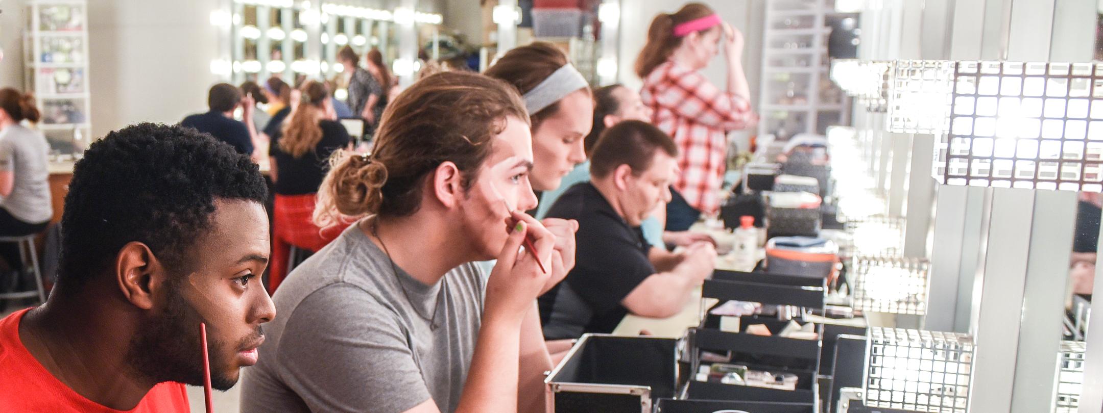 Diverse students put on makeup backstage at Williams theatre