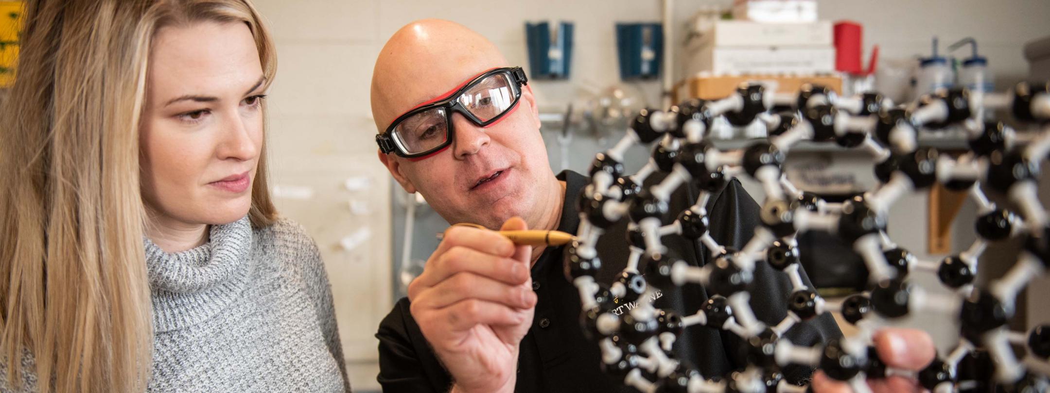 Chemistry professor explaining a molecule frame work to a student.