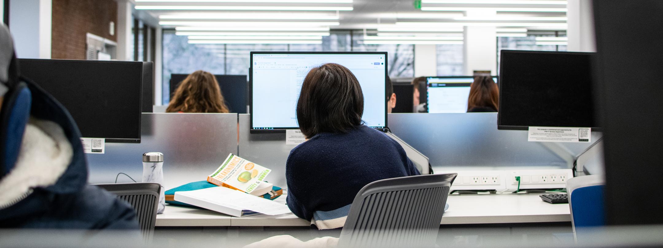 Student studying her class notes in a computer lab.