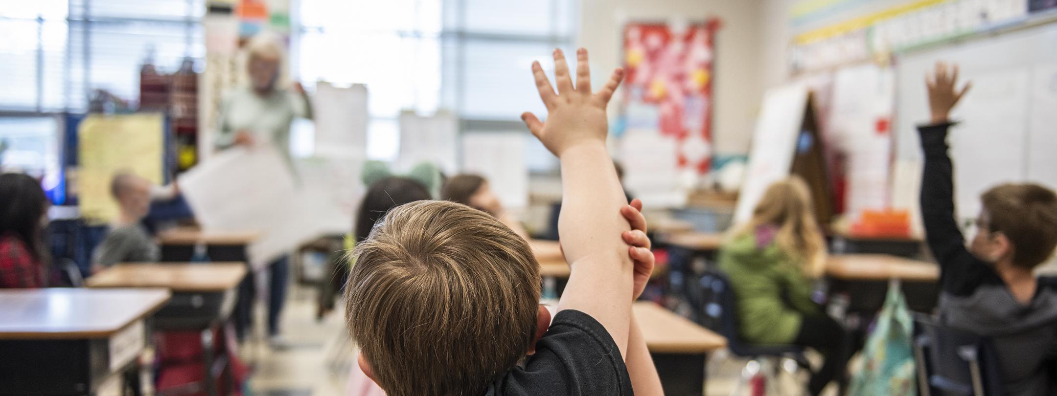 A child has a question in an elementary classroom