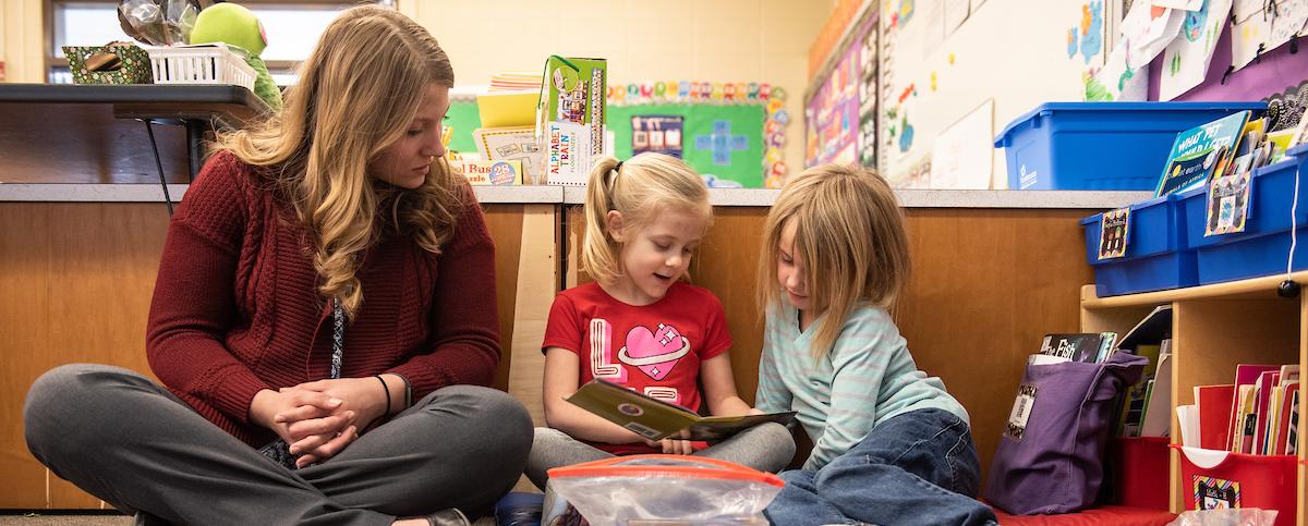 Teacher and young students reading