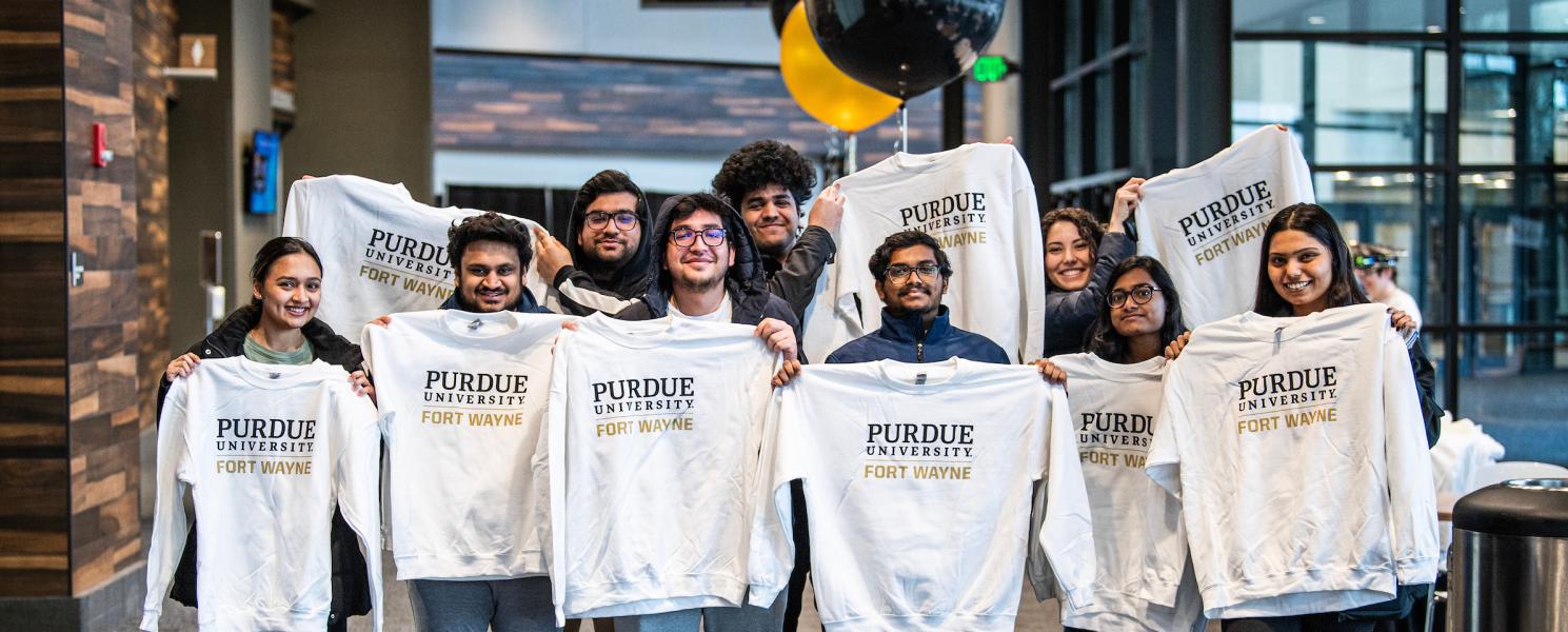 Students hold up PFW sweatshirts.