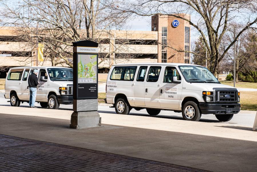 Two student shuttle vans waiting on students.