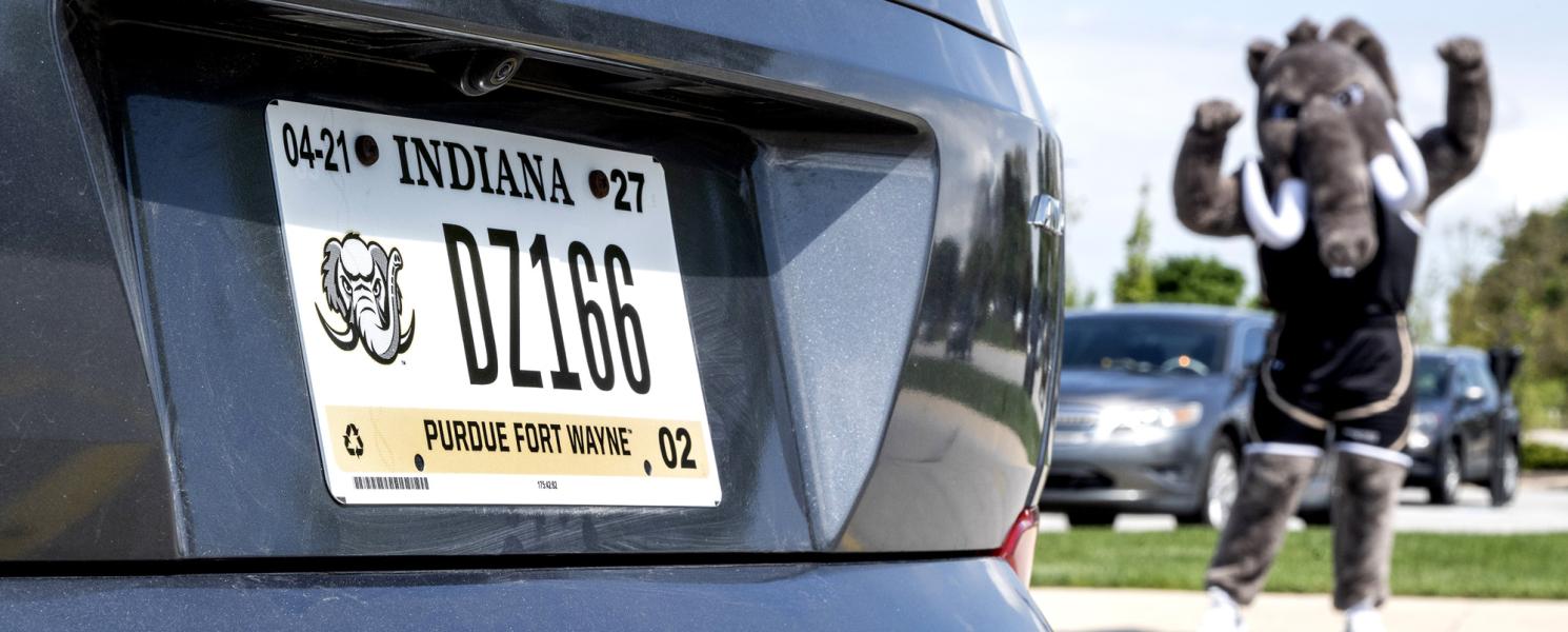 Don poses next to a car with a PFW license plate