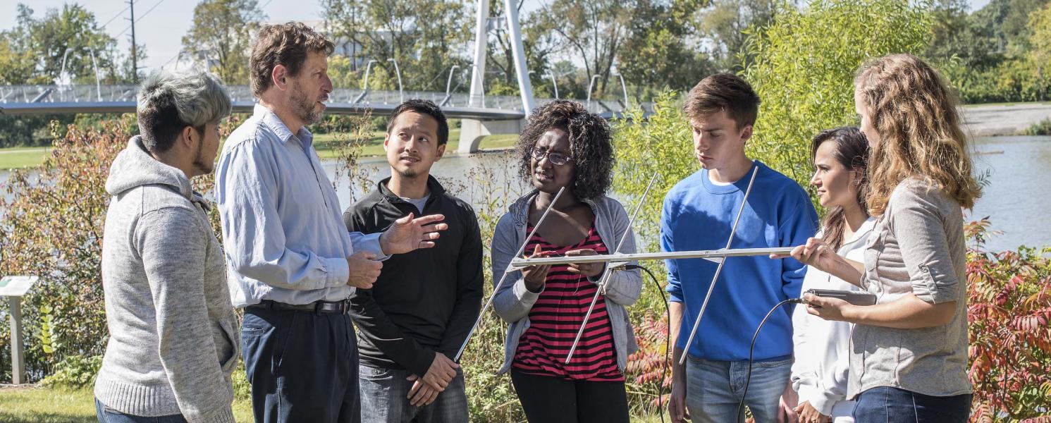 Biology professor explaining the use of an antenna in field research.