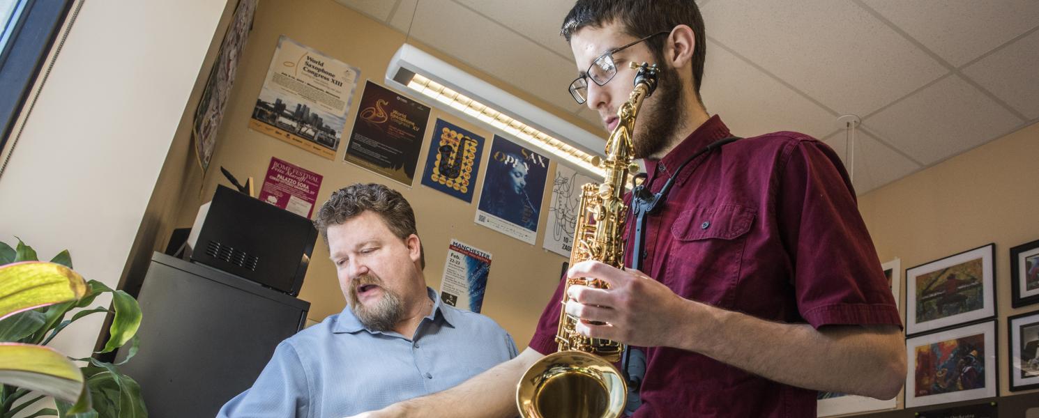 Professor teaching a saxophone student.