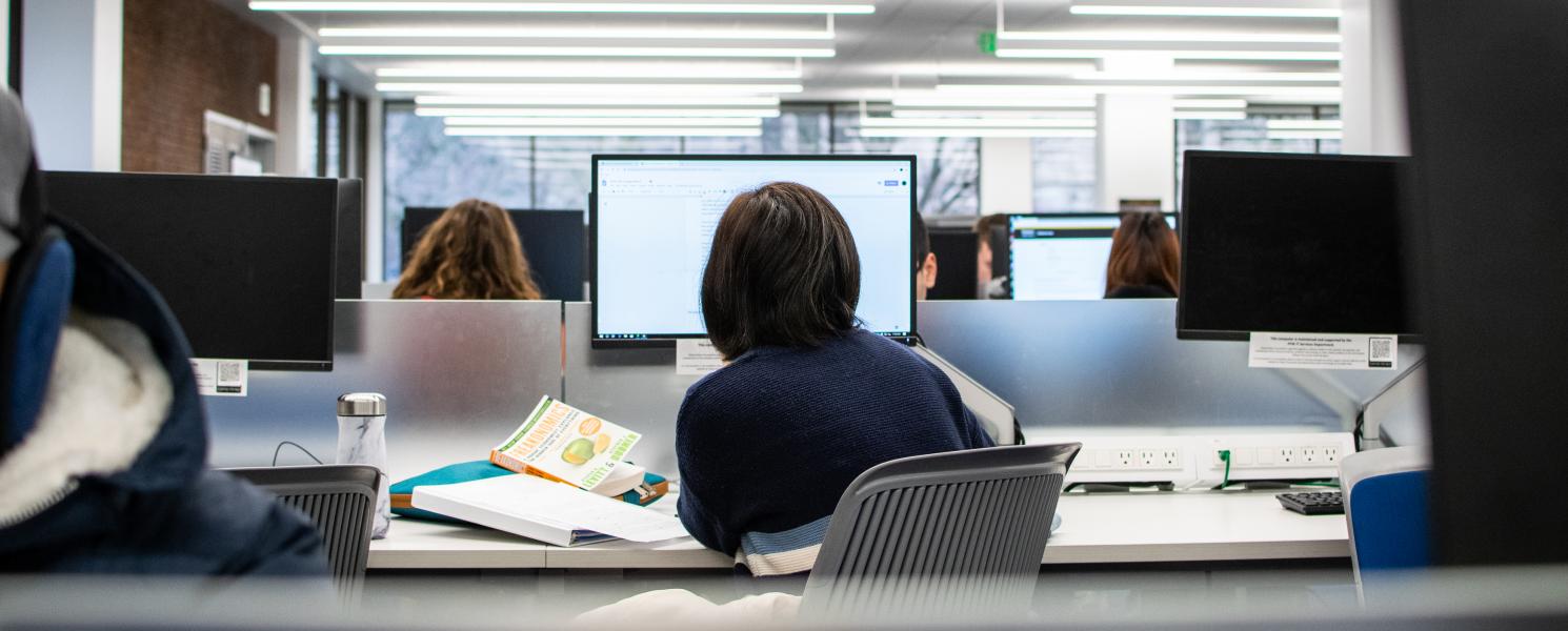 Student studying her class notes in a computer lab.