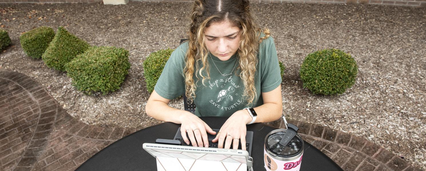 Student studying her class notes on her laptop.