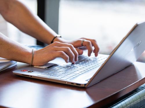 Student types on a laptop.