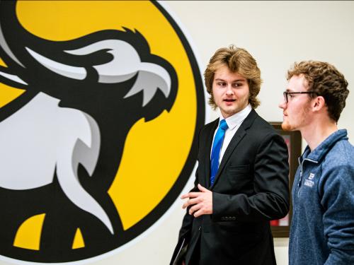 Two students walk together and prep for an interview.